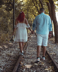 Rear view of people walking in forest