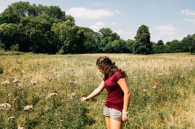 Rear view full length of woman standing on grassy field