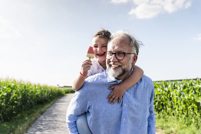 Grandfather carrying granddaughter piggyback