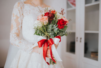 Red rose bouquet against white wall