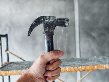 Close-up of hand holding hammer at construction site