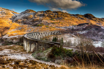 Scenic view of bridge over mountains against sky