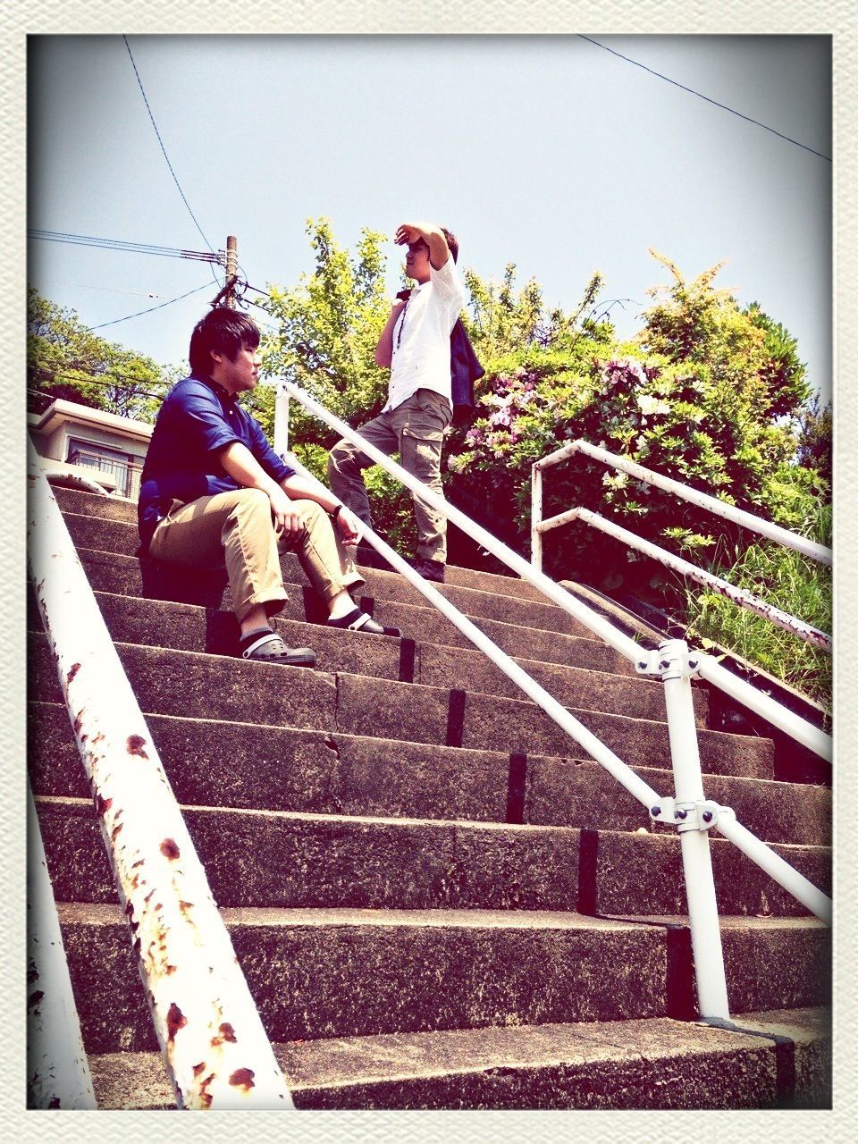 transfer print, auto post production filter, railing, railroad track, steps, low angle view, sky, rail transportation, staircase, steps and staircases, lifestyles, day, built structure, outdoors, full length, men, sunlight, leisure activity