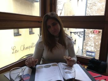 Young woman holding camera on table