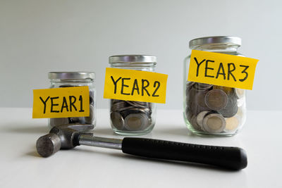 Coins and hammer on table against white background