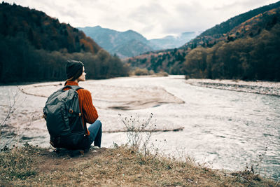 Rear view of man sitting on land