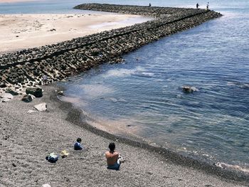 High angle view of people sitting on beach