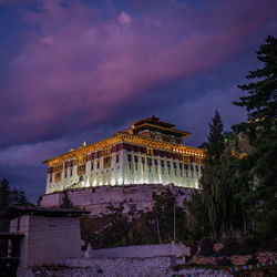 Low angle view of illuminated building against sky at dusk