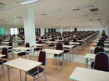 Empty chairs and tables arranged in row