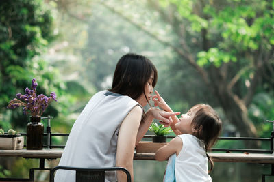 Side view of mother and daughter on plant