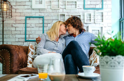 Couple romancing while sitting on sofa