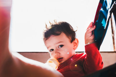 Portrait of cute boy looking away at home