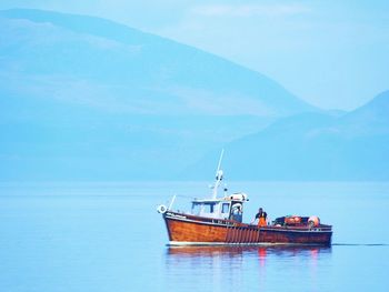 Boat sailing in sea against sky