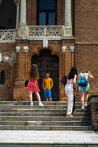 Rear view of couple standing on staircase outside temple