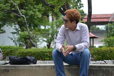 Full length of young man sitting in park