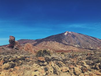 Scenic view of mountain against blue sky