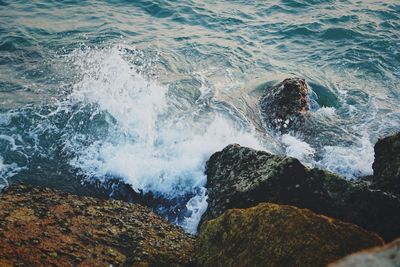 High angle view of waves splashing on rocks