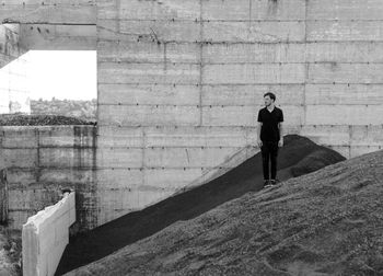 Full length of woman standing against wall