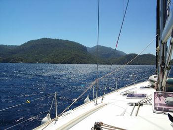 Sailboats sailing on sea against clear blue sky