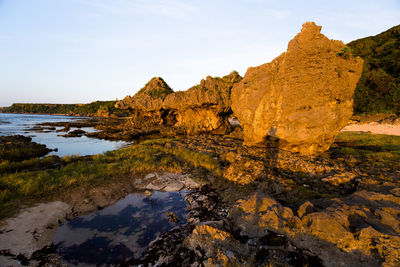 Scenic view of rock formation in lake against sky