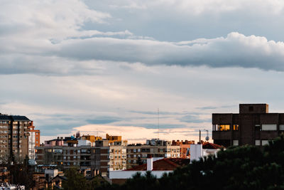 Buildings in city against cloudy sky