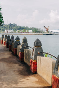 View of boats in river against cloudy sky