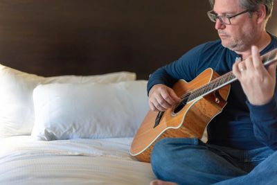 Midsection of man playing guitar