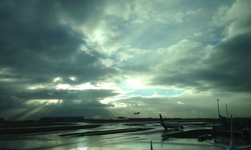 Boats in river against cloudy sky at sunset