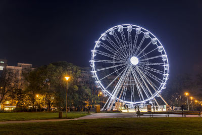 Illuminated ferris wheel at night