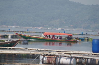 Boats moored in river against sky