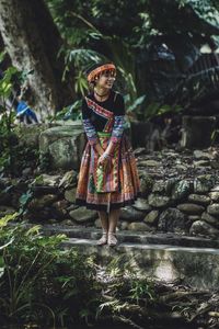 Woman standing against trees