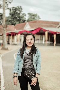 Portrait of young woman standing on street