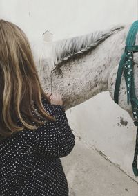 Rear view of girl braiding horse hair