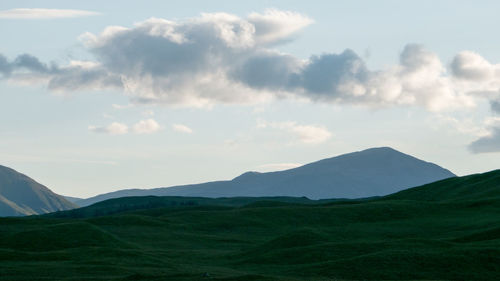 Scenic view of field and mountains against sky