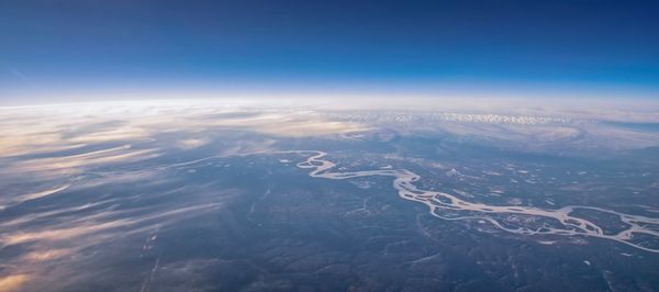 Aerial view of dramatic landscape against blue sky