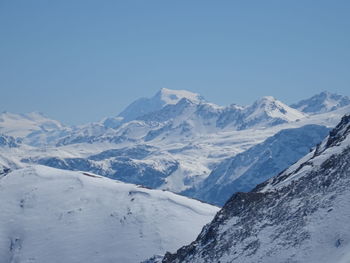 Scenic view of snowcapped mountains against clear blue sky