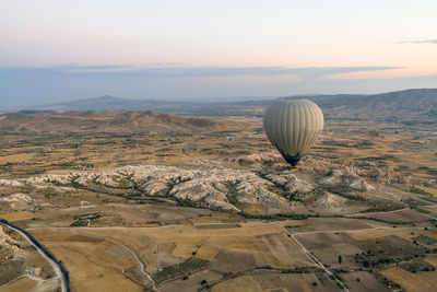 Hot air balloon flying over landscape against sky