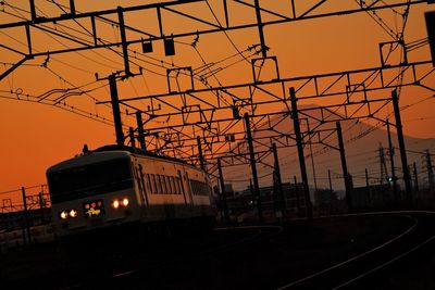 Train at railroad tracks against sky during sunset