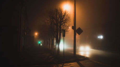 Illuminated street light on road at night