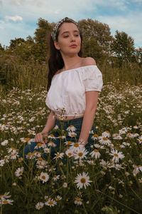 Full length of girl with flowers on field
