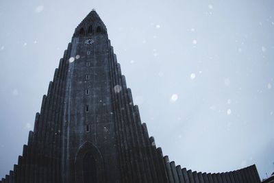 Low angle view of hallgrimskirkja against sky during snowfall