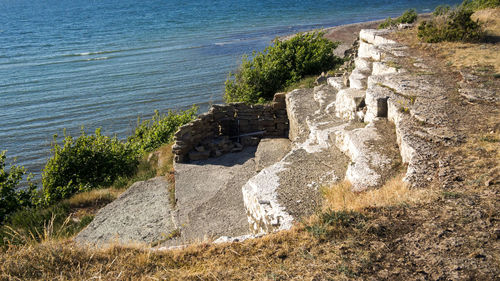 View of old stone wall by sea