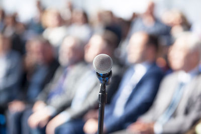 Close-up of microphone against crowd during event