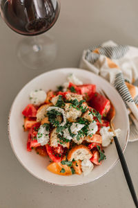 Italian pancanella salad in deep plate. fresh heirloom tomatoes. red wine in glass.