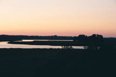 Scenic view of lake against orange sky