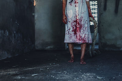 Low section of woman standing on street against building