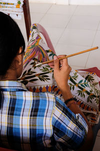 High angle view of woman painting fabric in workshop