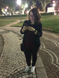 Portrait of smiling woman on footpath in city