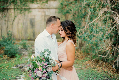 Side view of bride holding bouquet