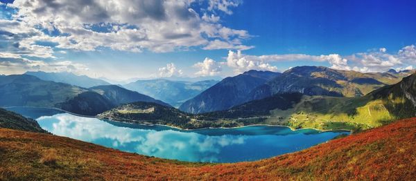 Panoramic view of lake and mountains against blue sky